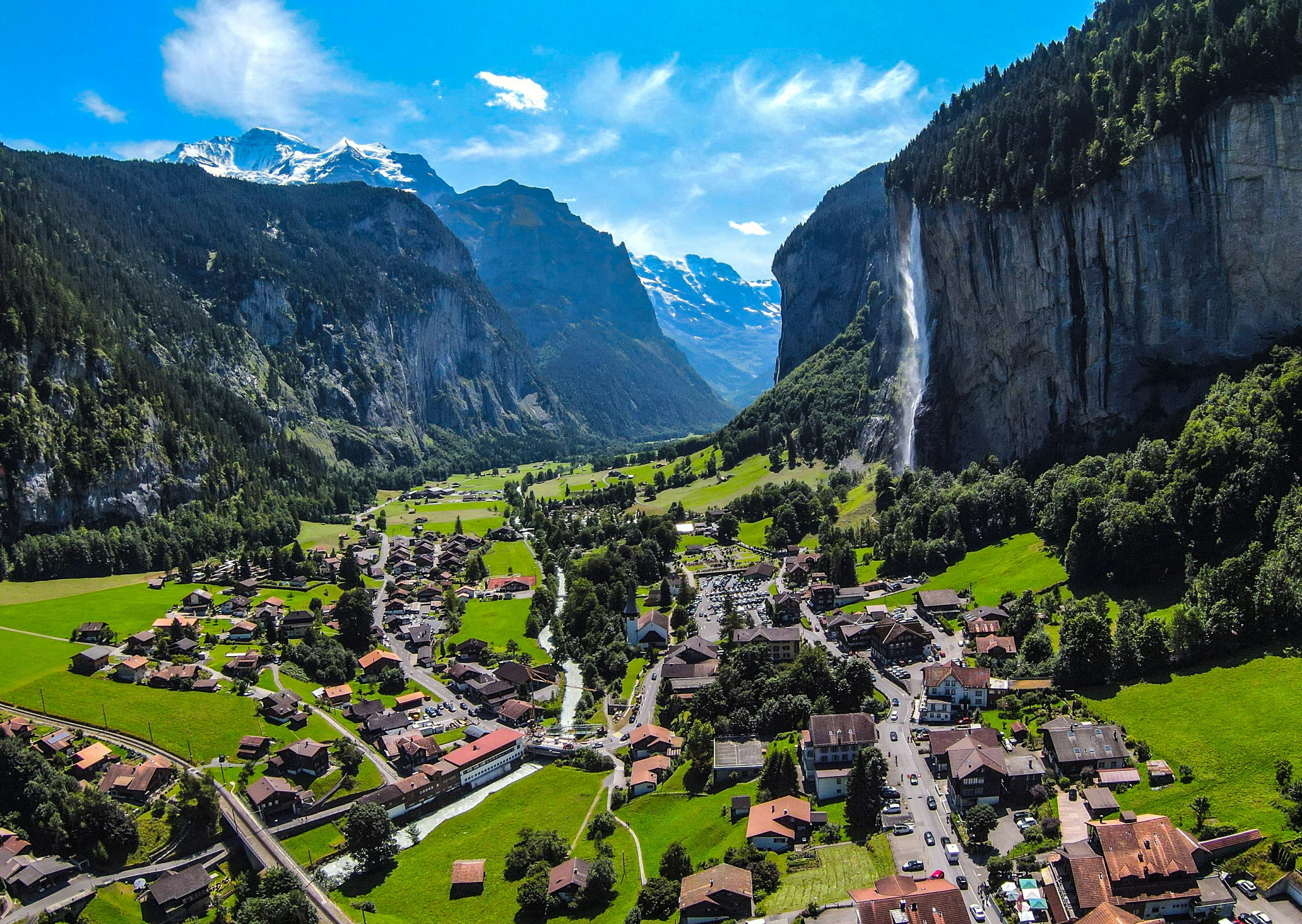 Lauterbrunnen vallei in het Berner Oberland — steile bergwanden met witte watervallen, alpenweiden en een klein Zwitsers dorp in de diepte.